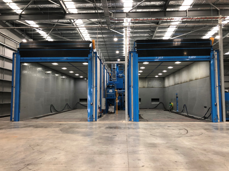 Twin Burwell heavy duty industrial blast rooms with concrete tilt panel walls and roll-up doors
